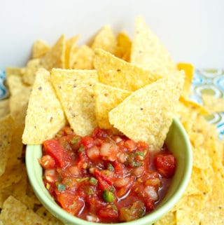 Salsa in a bowl with chips laying around