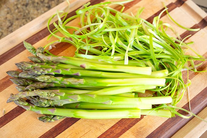 The same stack of asparagus is peeled from the middle of the stalk down.