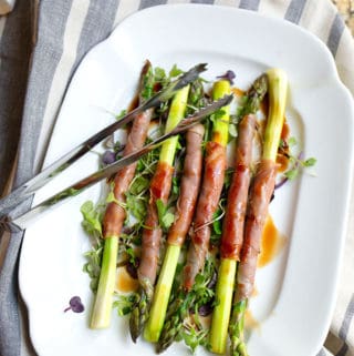 Sauteed asparagus spears wrapped in prosciutto and drizzled with balsamic