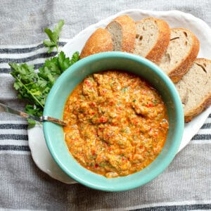Roasted Red Pepper Tapenade in a serving bowl with sourdough bread slices alongside