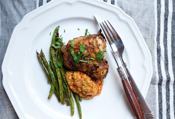 Tapenade on a plate with grilled chicken and sauteed green beans