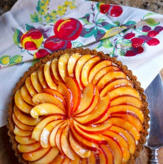 Nectarine Cream Tart in a gingersnap crust on a board with pie server