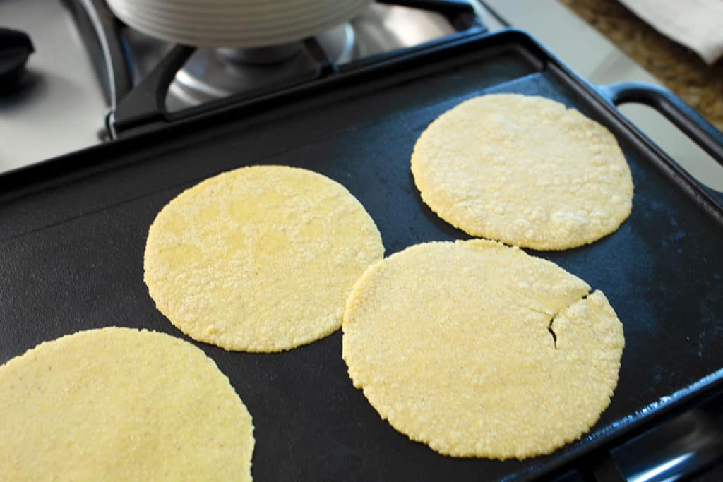 Tortillas cooking on a cast iron griddle