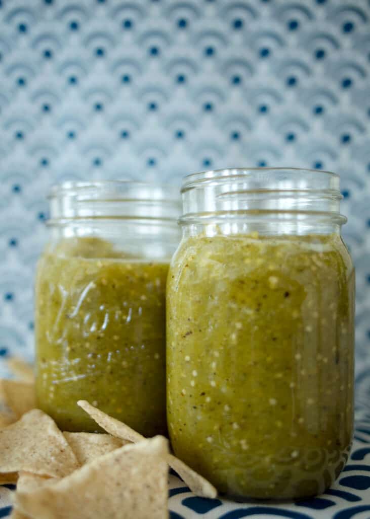 two jars of salsa verde and some chips