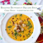 Bowl of roasted butternut squash soup garnished with bacon, parsley, and croutons