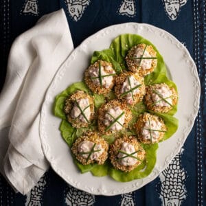 Crabcakes on a lettuce-lined white platter with a white linen napkin