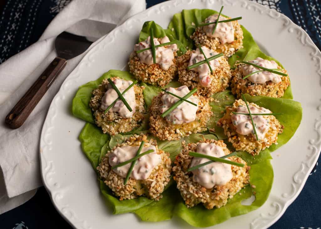 Close-up of crabcakes with aioli on top with chives as garnish