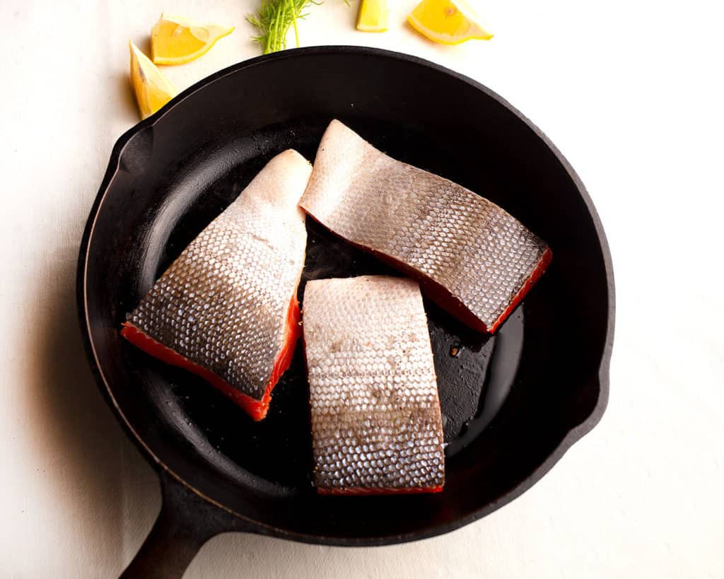 Salmon flesh-side down in the cast iron skillet
