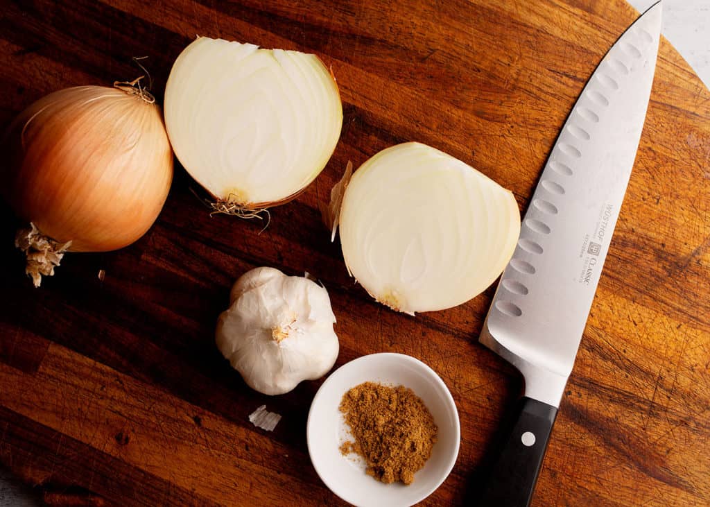 Onion, garlic, and cumin on the cutting board