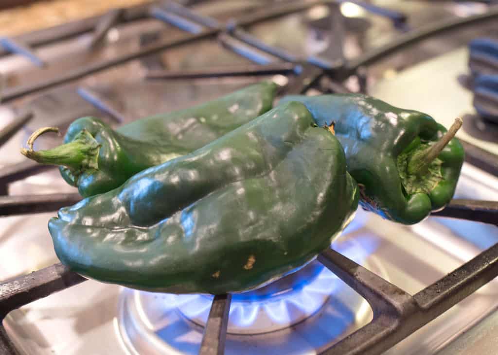Roasting the poblano chiles on the gas stove