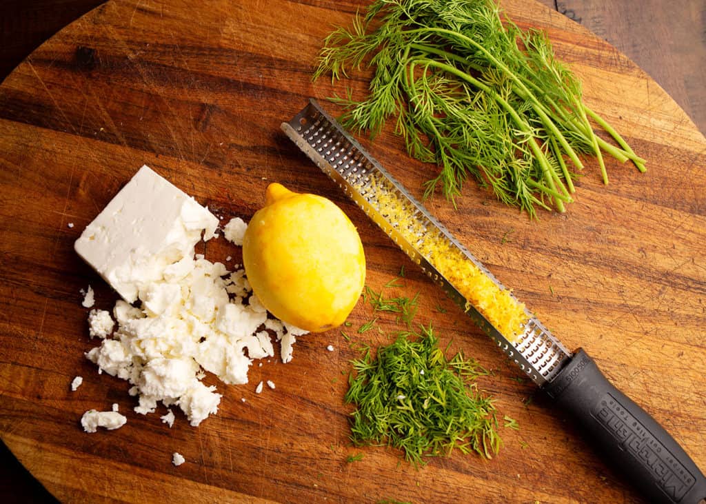 Dill, zested lemon, and feta on the cutting board