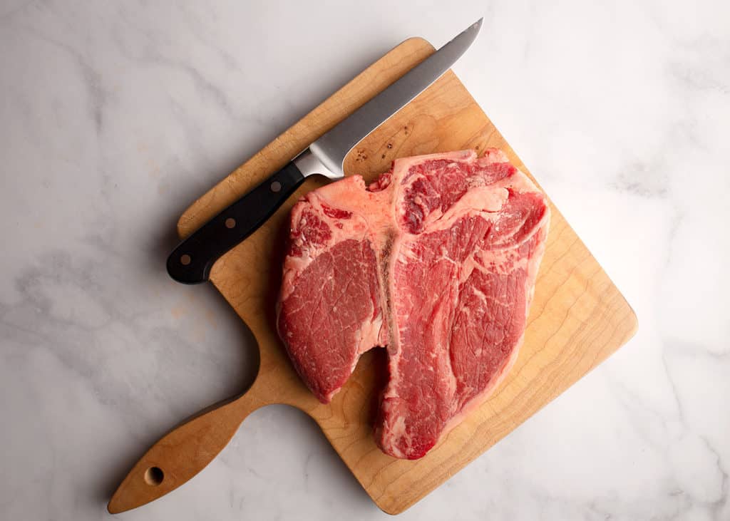 A porterhouse steak laying on a cutting board