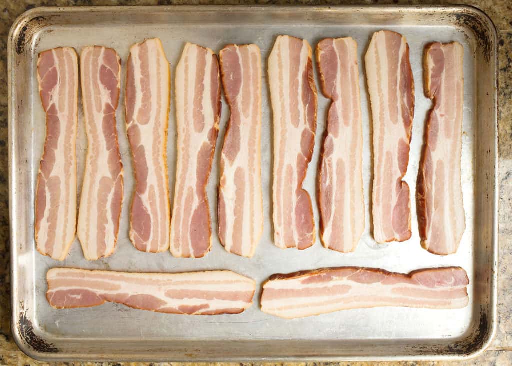Bacon laid on a baking sheet ready to bake