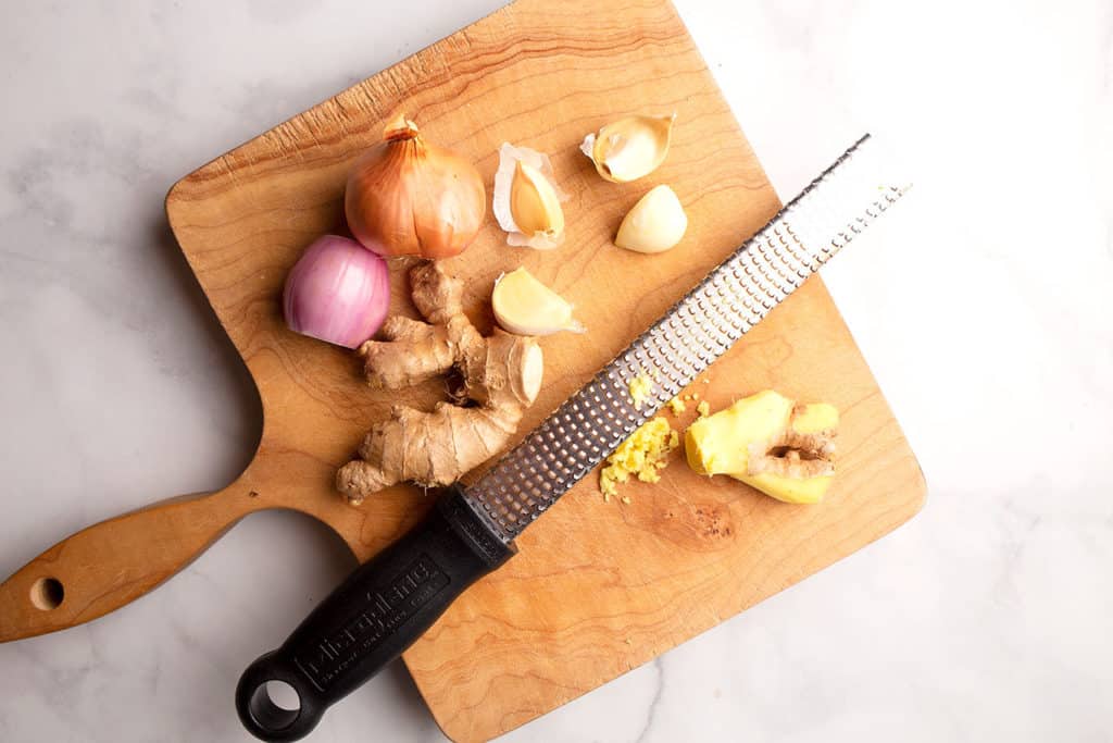 Shallots, garlic, and ginger on a cutting board