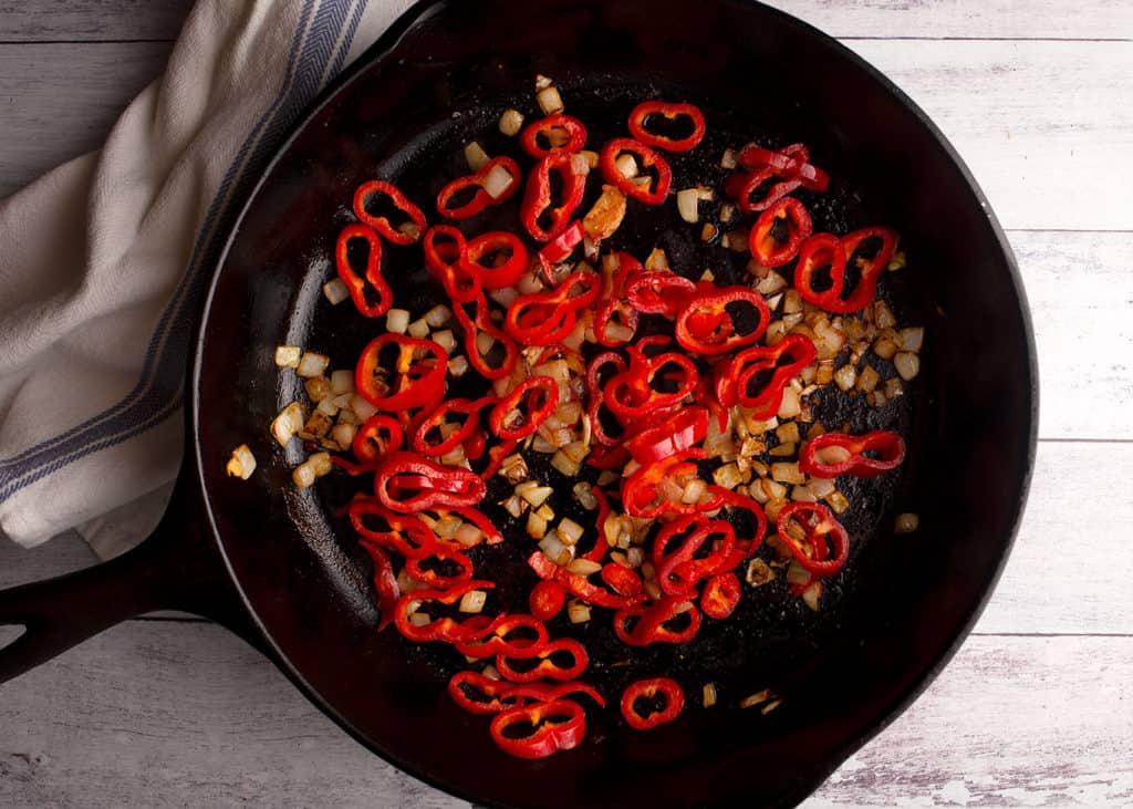 Sauteed onions and red pepper rings in cast iron