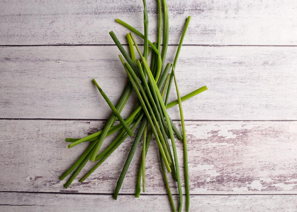 Chives on a chippy white plank board