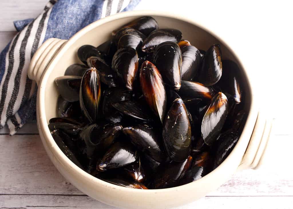 Washed and debearded mussels in a pottery bowl