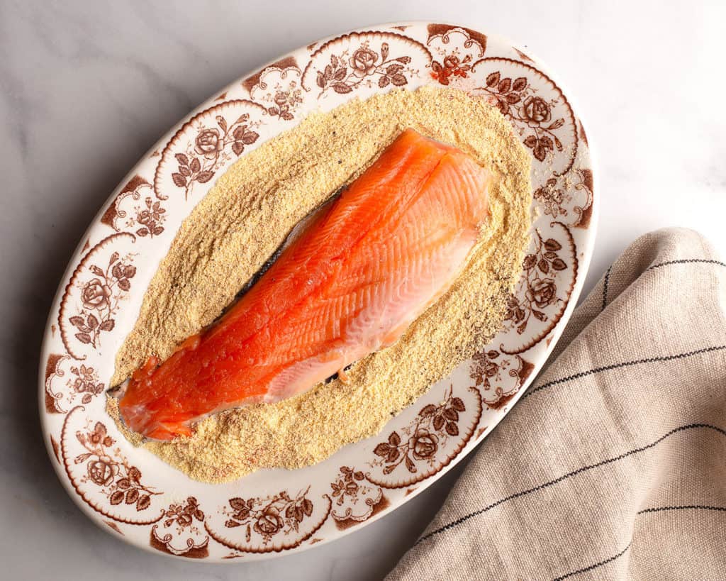 Coating the filleted trout with the spiced cornmeal crust
