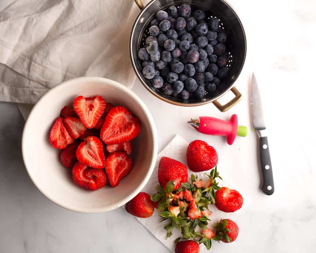 Blueberries in a copper colander, strawberries in a vintage bowl