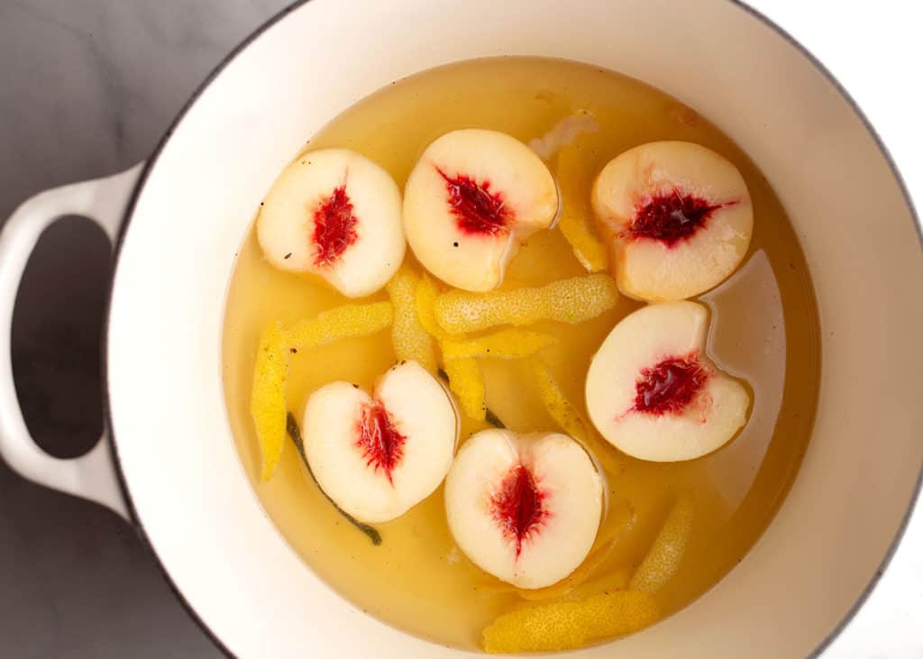 Peach halves marinating in the lemon/vanilla sugar water