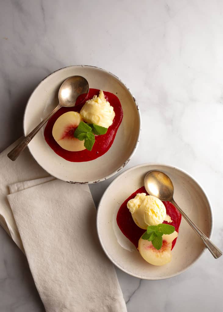 Two plates of Peach Melba served with ice cream