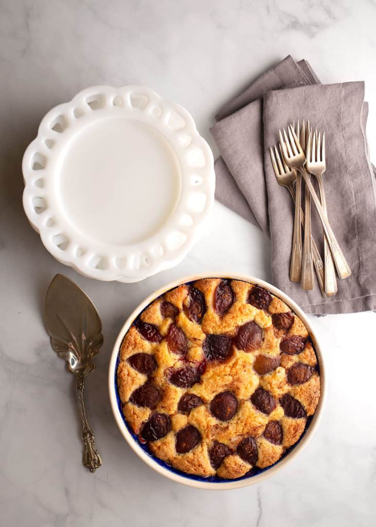 Italian Plum Cake with serving plates and forks - vertical image