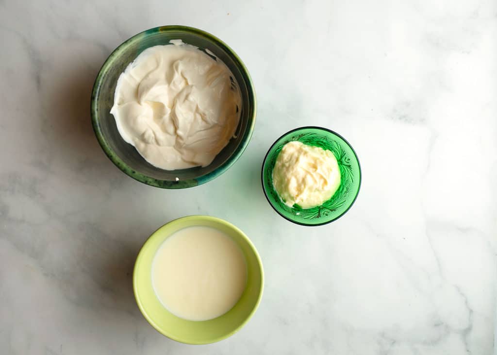 Sour cream, mayonnaise, and buttermilk measured in bowls