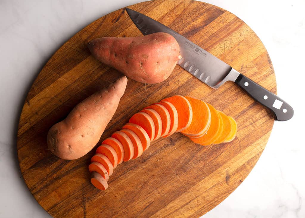 Sweet potatoes sliced on a cutting board