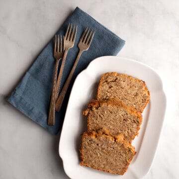 slices of spiced banana oat bread on a vintage ironstone platter