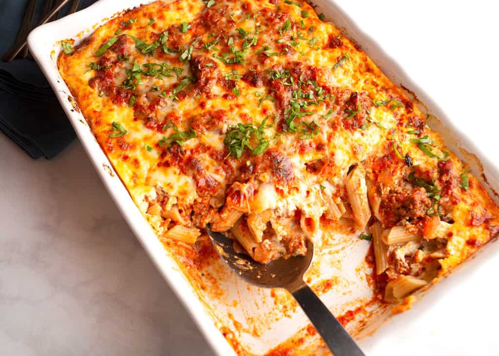 Baking dish of Baked Ziti with Meat Sauce with a serving removed