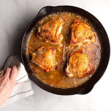 A beautiful skillet of Apple Cider Braised Chicken straight from the oven