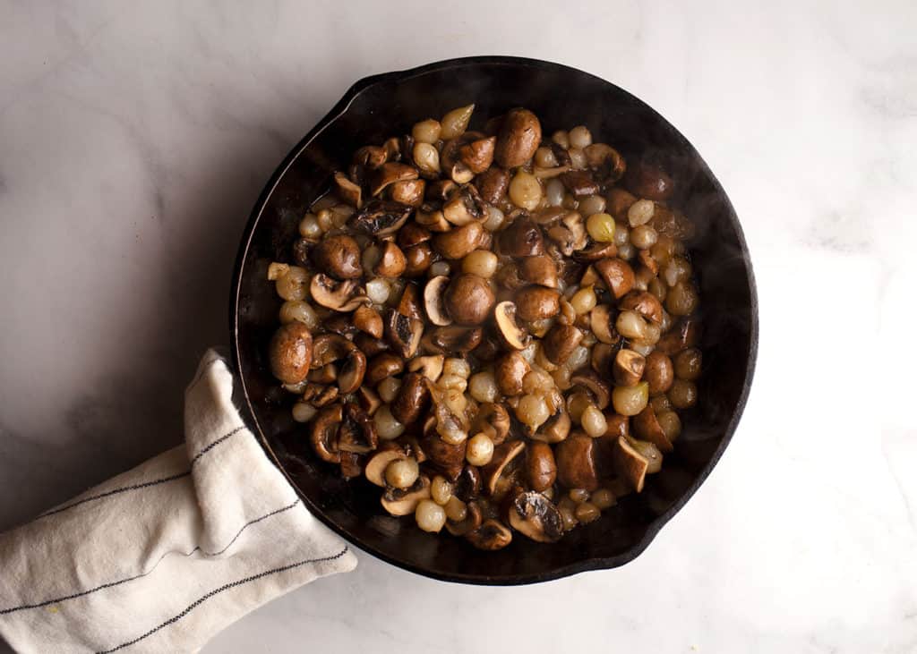 Pearl onions with mushrooms in a skillet cooked separately