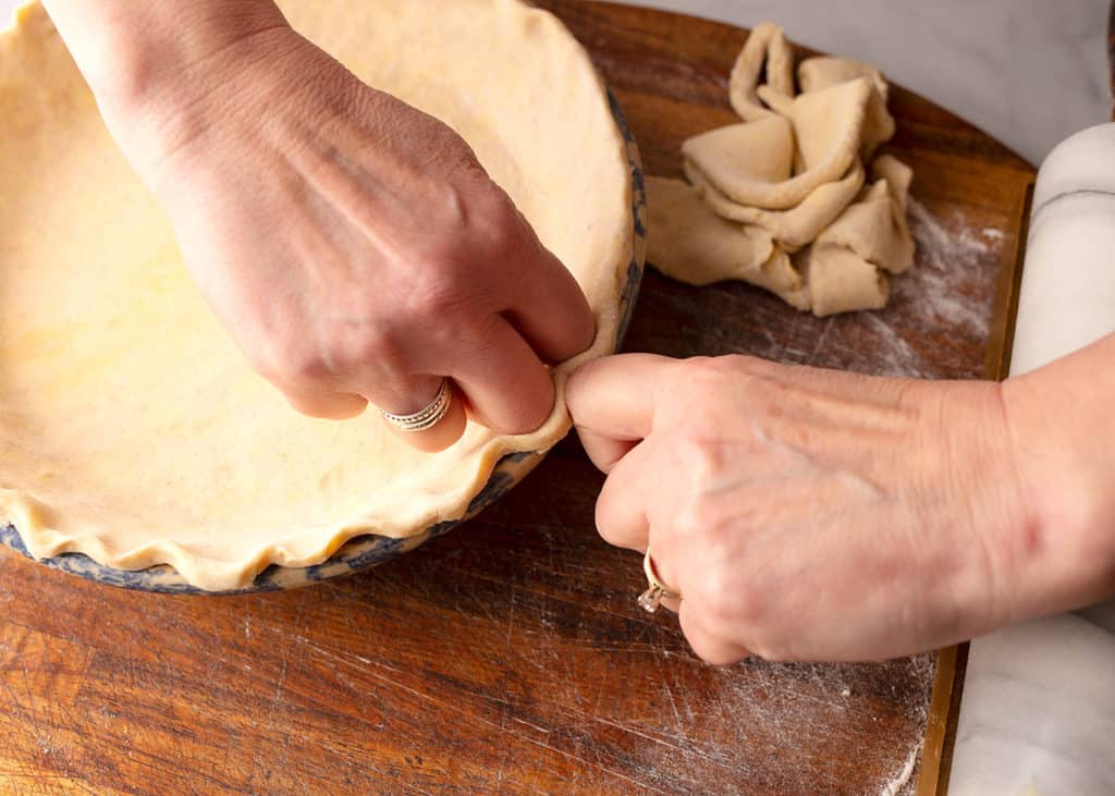 using knuckles to crimp the crust edges