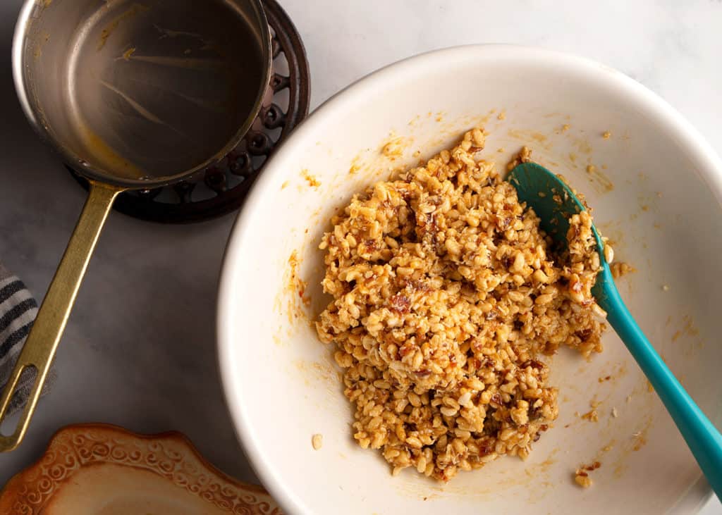 The syrup mixture combined with the crispy rice, coconut, and walnuts