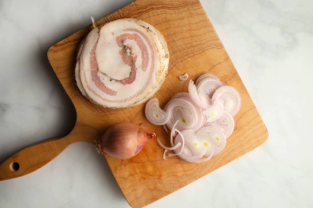pancetta and shallots on cutting board