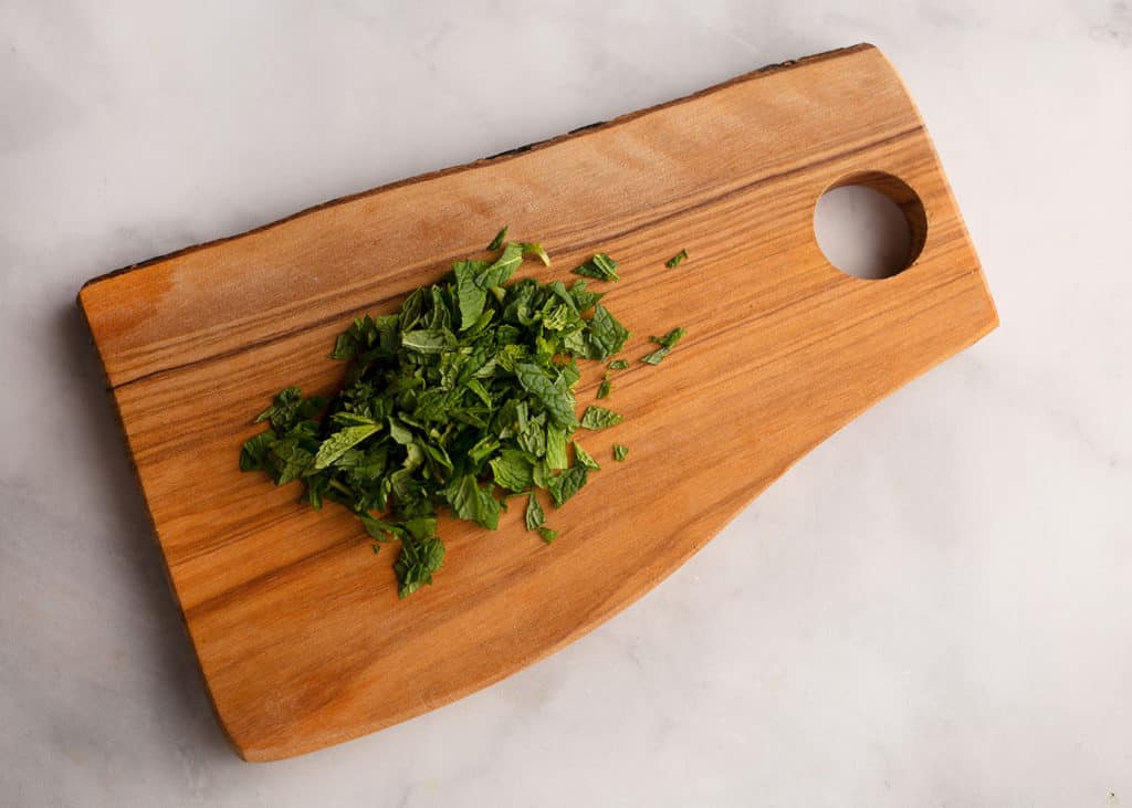 chopped mint on a live edge cutting board