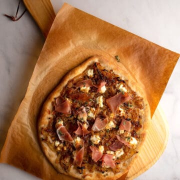 Caramelized Onions & Goat Cheese Pizza on a pizza peel