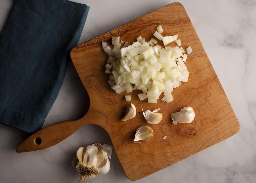 onions and garlic on cutting board