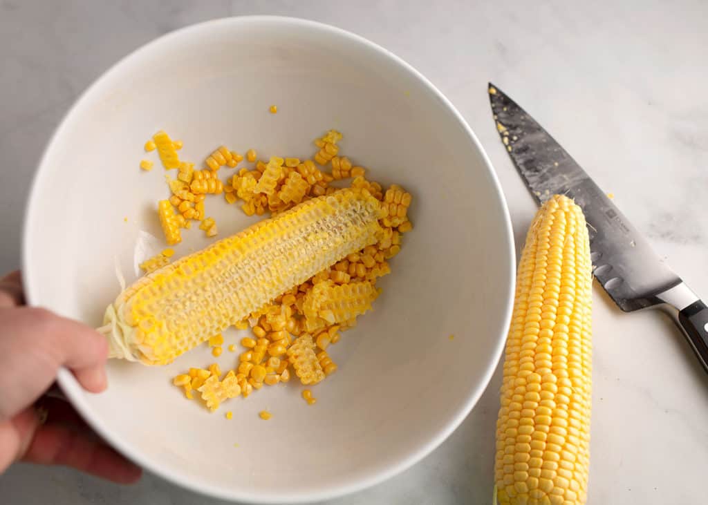 Cutting the corn off the cob into a bowl