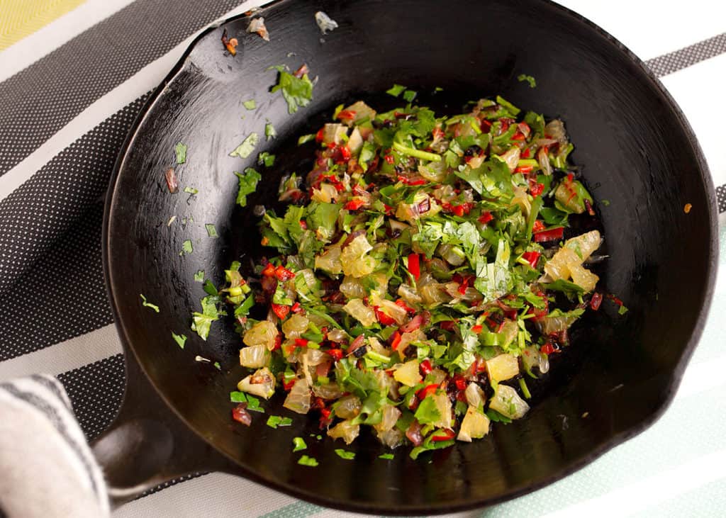 The garnish in the skillet. Cook the red onion and jalapeno pepper first, then add the diced lime and cilantro