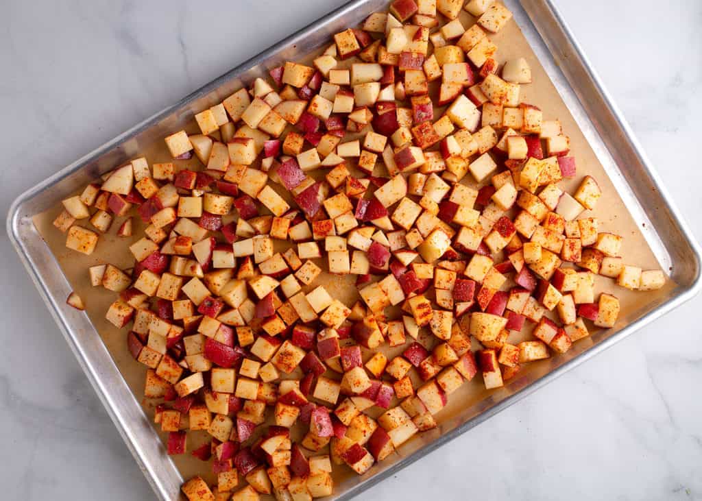 Diced potatoes on a baking sheet with parchment paper
