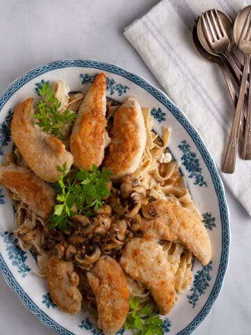 Platter of chicken strips with mushrooms on pasta