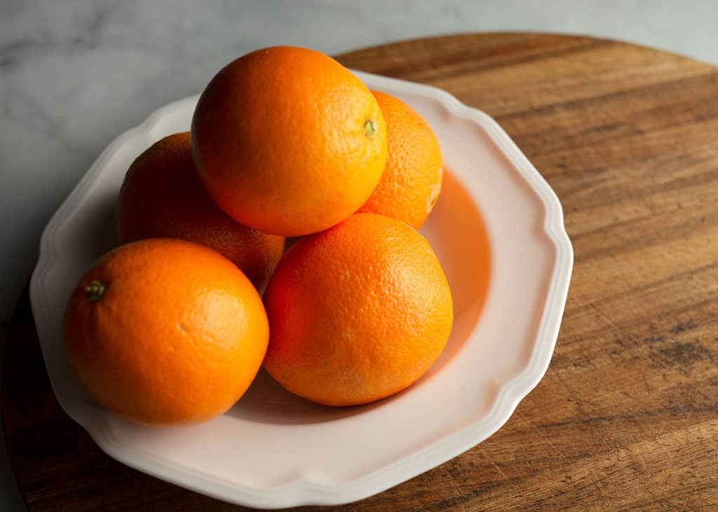 Fresh navel oranges in a white bowl