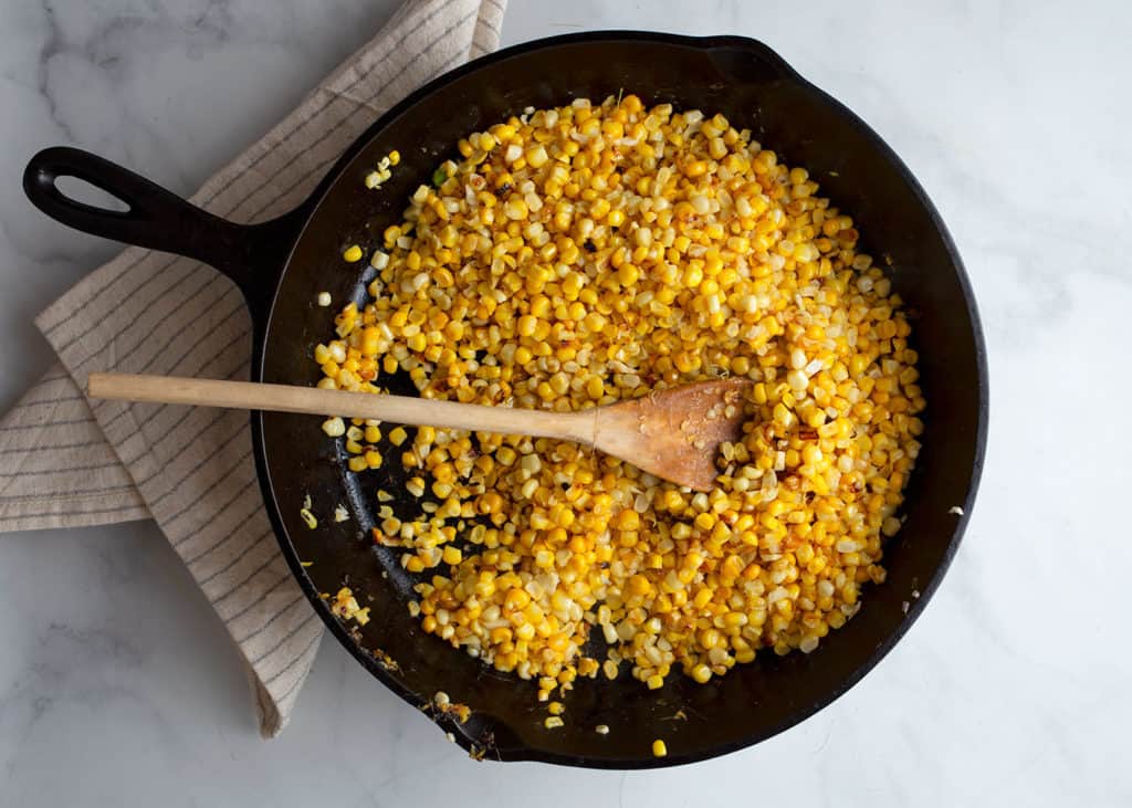 Caramelized kernels of corn in a cast iron skillet