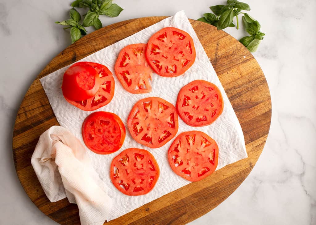 Tomato slices in one layer on paper towels