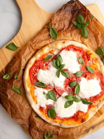 Margherita Pizza on parchment paper on a pizza peel
