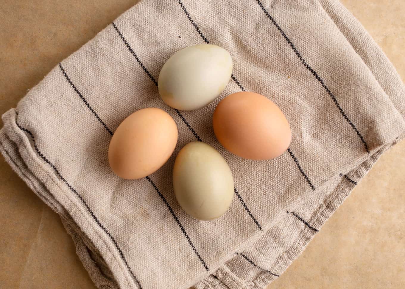 Four colorful farm fresh eggs on a linen towel