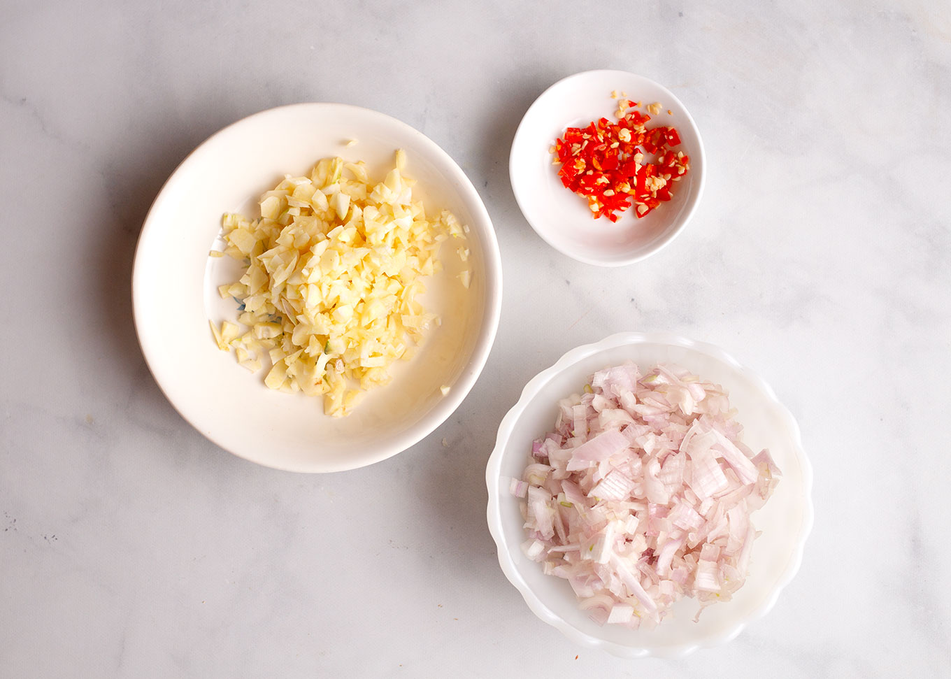 chopped shallot, garlic, and peppers in separate bowls