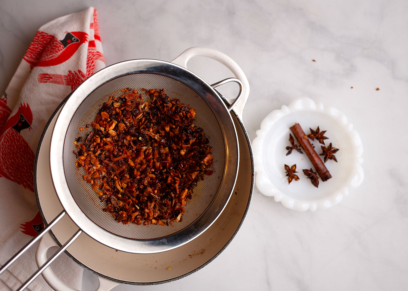 Shallot, garlic, and peppers strained from the oil with the cinnamon and star anise set aside.