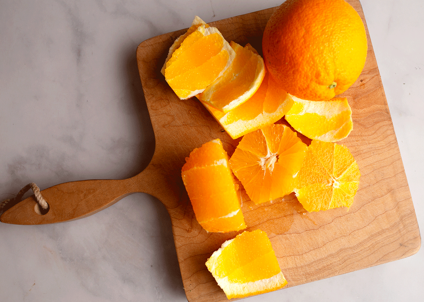 Oranges peeled and sliced on a cutting board